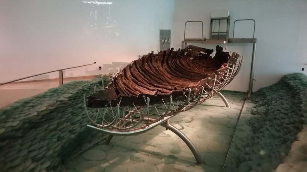 Hölzerner Rumpf eines antiken Fischerboots auf einem Metallgestell im Museum
