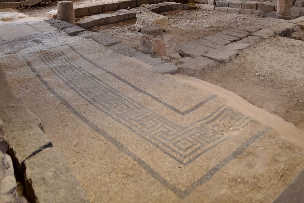 Freigelegter Steinboden mit Mosaikband in der antiken Synagoge von Magdala